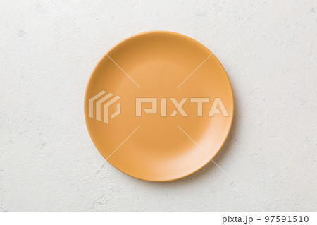 Top view of empty orange plate on cement background. Empty space for your design 97591510