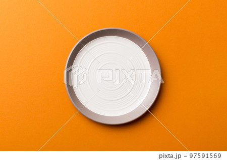 Top view of isolated of colored background empty round white plate for food. Empty dish with space for your design Top view of isolated of colored background empty round white plate for food. Empty dish with space for your design 97591569
