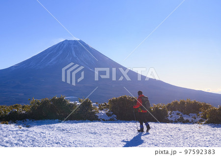 山梨県・竜ヶ岳山頂より富士山を望む登山者 97592383