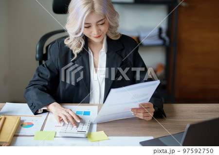 Accountants, Asian auditors are using calculators and computers to review annual tax budgets to submit information to the IRS Accountants, Asian auditors are using calculators and computers to review annual tax budgets to submit information to the IRS 97592750