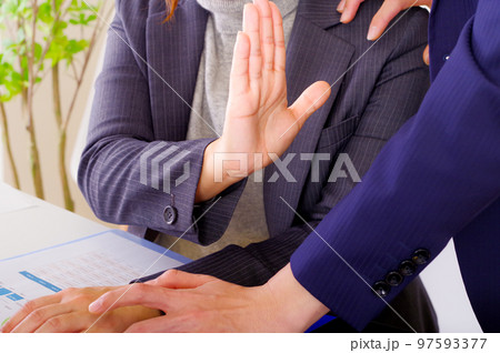 手のひらで拒否の意思を示す女性 97593377