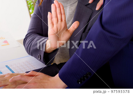 手のひらで拒否の意思を示す女性 97593378