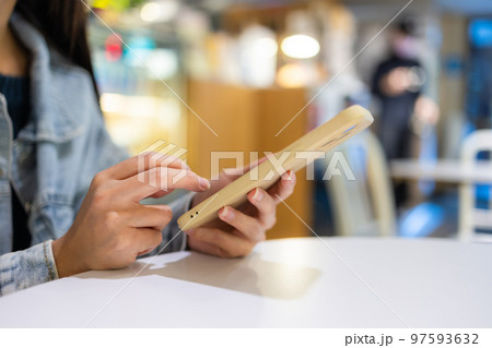 Woman use of smart phone in coffee shop 97593632