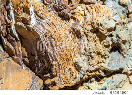 The texture of the stone.Heavy, rough texture of the rock in warm tones of ancient stone. The texture of the stone.Heavy, rough texture of the rock in warm tones of ancient stone. 97594604