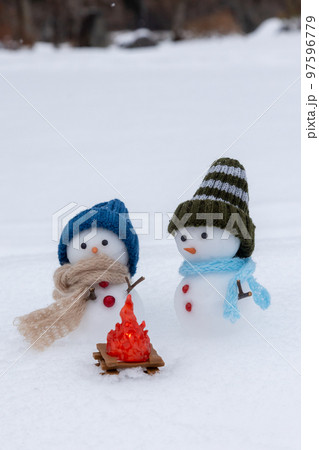 焚火にあたる二人の雪だるま 97596779