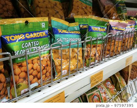 SELANGOR, MALAYSIA -FEBRUARY 5, 2022: Peanut-based snacks packed in commercial packs and hung for sale. Sorted by brand and has a price tag. SELANGOR, MALAYSIA -FEBRUARY 5, 2022: Peanut-based snacks packed in commercial packs and hung for sale. Sorted by brand and has a price tag. 97597395