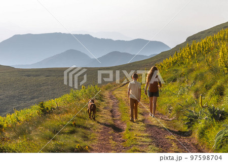 Happy Family with Child and Dog Hiking in Mountains Happy Family with Child and Dog Hiking in Mountains 97598704