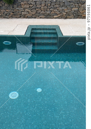 View of the modern outdoor swimming pool with clear water. Rest in the water. Swimming in the pool. 97598861