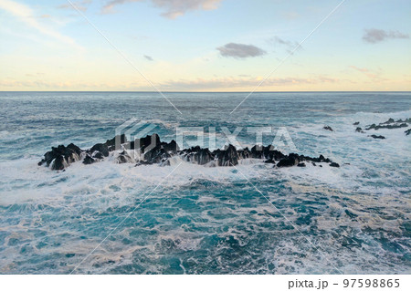 The waves of the ocean break on the rocks of the island. Turquoise ocean wave. Background of rest and relaxation. Meditation. Nature, sea background. 97598865