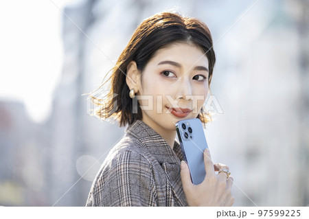 スマートフォンを持ったアラサーの女性 スマートフォンを持ったアラサーの女性 97599225