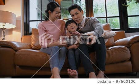 Family concept of 4k Resolution. Asian parents and children watching movies together at home on vacation. 97600100
