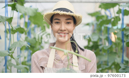 Agricultural concept of 4k Resolution. Asian woman holding produce handing over with a smile. 97600173