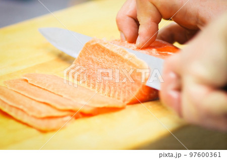 close up. professional chef slicing thin slices of salmon 97600361