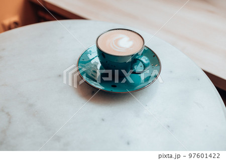 closeup of a cup of latte coffee on white marble table, cafe, copy space 97601422
