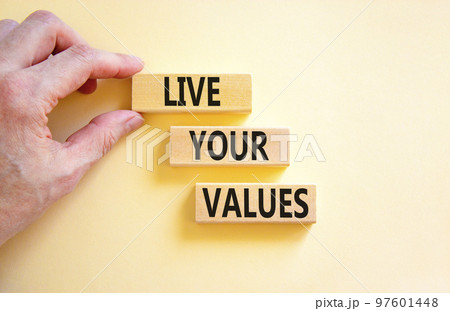 Live your values symbol. Concept words Live your values on wooden blocks. Businessman hand. Beautiful white table white background. Business, psychological and live your values concept. Copy space. 97601448