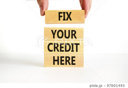Fix your credit here symbol. Concept words Fix your credit here on wooden blocks on a beautiful white table white background. Businessman hand. Business, finacial and fix your credit here concept. 97601493