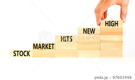 Stock market hits new high symbol. Concept words Stock market hits new high on wooden blocks on a beautiful white background. Businessman hand. Business stock market hits new high concept. Copy space 97601498