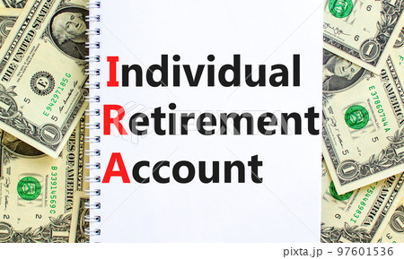 IRA individual retirement account symbol. Concept words IRA individual retirement account on white note on background from dollar bills. Business IRA individual retirement account concept. Copy space IRA individual retirement account symbol. Concept words IRA individual retirement account on white note on background from dollar bills. Business IRA individual retirement account concept. Copy space 97601536