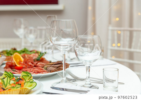 Served for holiday banquet restaurant table with dishes, snack, cutlery, wine and water glasses. 97602523