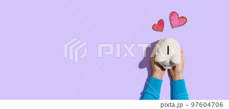 Person holding piggy bank with hearts Person holding piggy bank with hearts 97604706