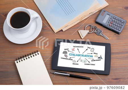 Collaboration concept. Tablet device on a wooden table Collaboration concept. Tablet device on a wooden table 97609082