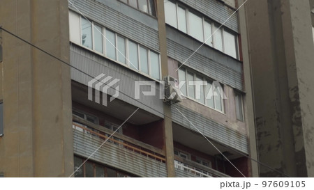Dilapidated post-Soviet building close-up. A dilapidated tenement building with balconies. Shooting from top to bottom. 97609105