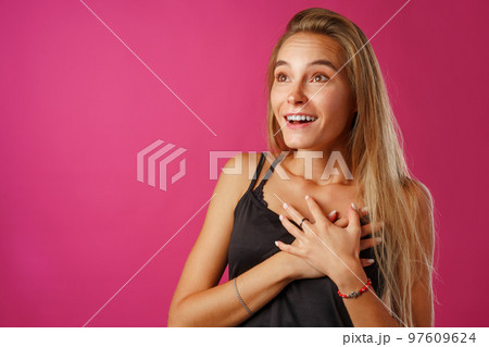 Peaceful young blonde woman holding hands on her chest. Peaceful young blonde woman holding hands on her chest. 97609624