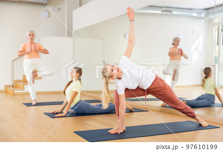 Three female relatives practicing yoga poses during training 97610199