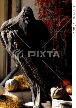 Dead man in black near pumpkins cemetery on Halloween Dead man in black near pumpkins cemetery on Halloween 97611319