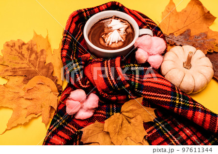 Autumn composition of a cup of coffee with marshmallow on a yellow background Autumn composition of a cup of coffee with marshmallow on a yellow background 97611344