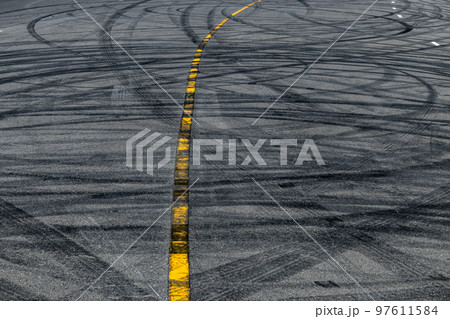 Tire track mark on asphalt tarmac road race track texture and background, Abstract background black tire tracks skid on asphalt road in racing circuit, Tire mark skid mark on asphalt road. Tire track mark on asphalt tarmac road race track texture and background, Abstract background black tire tracks skid on asphalt road in racing circuit, Tire mark skid mark on asphalt road. 97611584