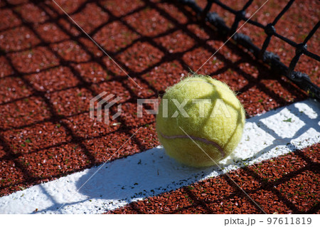 Tennis scene with black net, ball on white line Tennis scene with black net, ball on white line 97611819