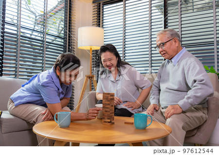 Elderly friends building tower from wooden cubes leisure time in nursing home. Elderly friends building tower from wooden cubes leisure time in nursing home. 97612544