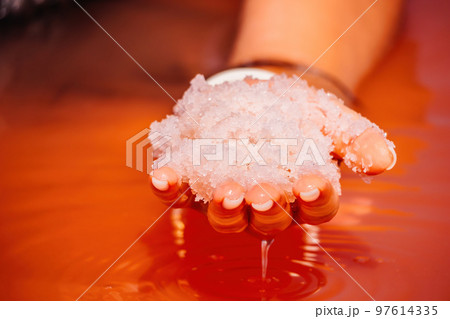 Young woman with long hair in pink salty lake with crystals of salt. Extremely salty pink lake, colored by microalgae with crystalline salt depositions. Spa, beauty and health care concept. 97614335