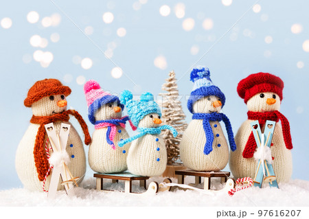 Knitted snowmen in colorful hats and scarves on a blue background. The concept of Christmas, New Year and winter fairy tale. Flat lay 97616207