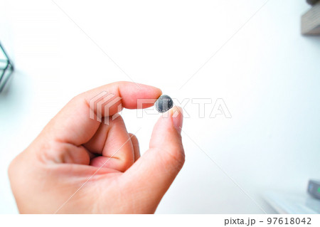 Coin cell or button cell battery LR1130 in hand Coin cell or button cell battery LR1130 in hand 97618042
