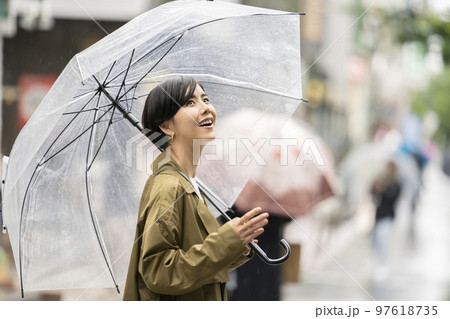 ビニール傘をさした笑顔の女性 97618735