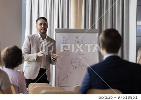 Male coach speaker in formal suit gives flip chart presentation Male coach speaker in formal suit gives flip chart presentation 97618861