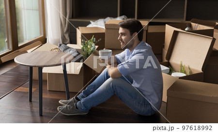 Happy thoughtful home owner man taking break from relocation activity Happy thoughtful home owner man taking break from relocation activity 97618992
