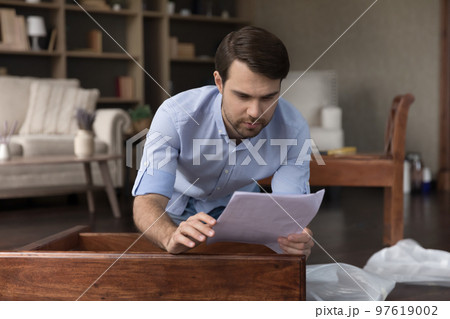 Puzzled homeowner man having troubles with assembling piece of furniture 97619002