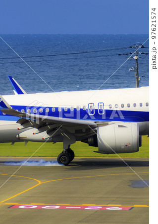 タイヤスモークを上げて着陸する航空機 97621574