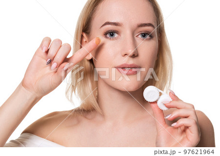 Young woman holding contact lenses cases and lens in front of her face on white background Young woman holding contact lenses cases and lens in front of her face on white background 97621964
