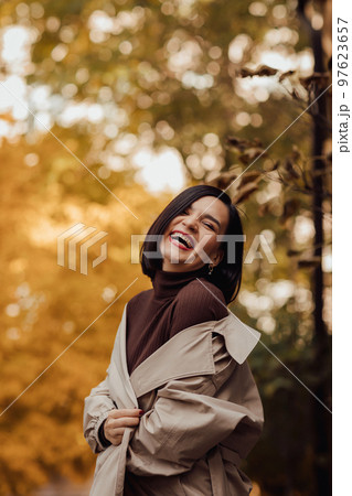 portrait of a happy attractive brunette in an autumn coat on a city street. portrait of a happy attractive brunette in an autumn coat on a city street. 97623657