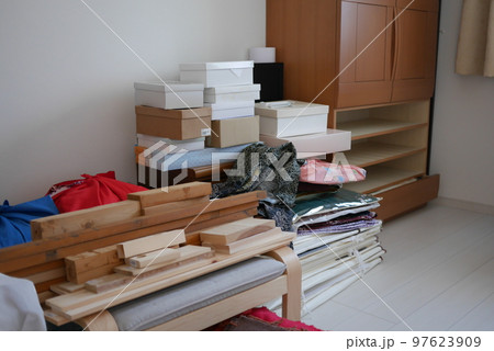 引き出しを抜いた和ダンスと荷物の山 97623909