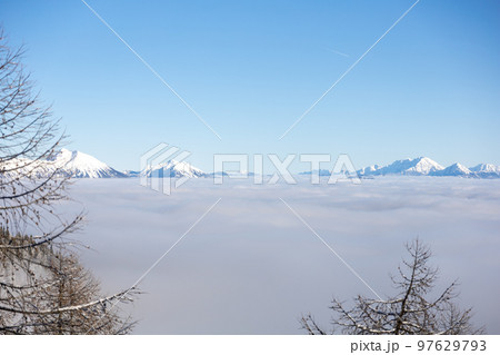 Winter mountains covered with snow landscape over clouds 97629793
