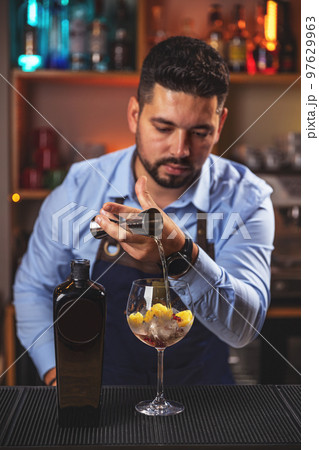 Barman gently pours drink 97629963