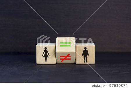 Symbol for gender equality. Turned a cube and changed a unequal sign to a equal sign between symbols of men and women. Beautiful black table black background, copy space. Gender equality concept. 97630374