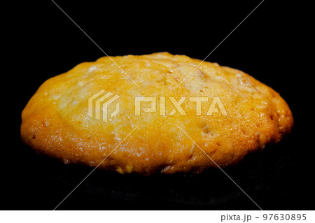 One baked homemade crunchy oatmeal cookie on metal sheet in oven One baked homemade crunchy oatmeal cookie on metal sheet in oven 97630895