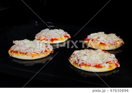 Four baked homemade mini pizzas in electric oven at home Four baked homemade mini pizzas in electric oven at home 97630896