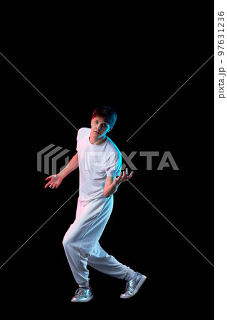 young man in black t-shirt and jeans dancing 97631236